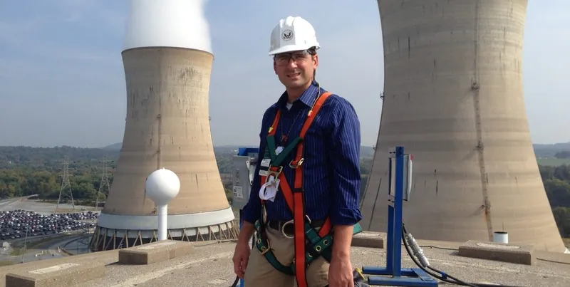 Inspectors on a nuclear reactor with cooling towers behind
